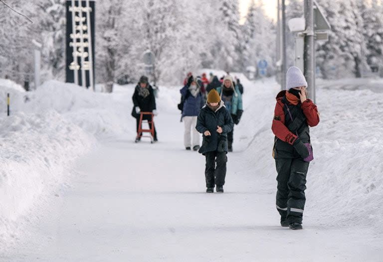 La gente camina en un paisaje nevado en la ciudad de Äkäslompolo, en el municipio de Kolari en la Laponia finlandesa el 4 de enero de 2024, durante condiciones de congelación extrema que persistirán durante toda la semana no solo en Laponia sino en toda Finlandia.