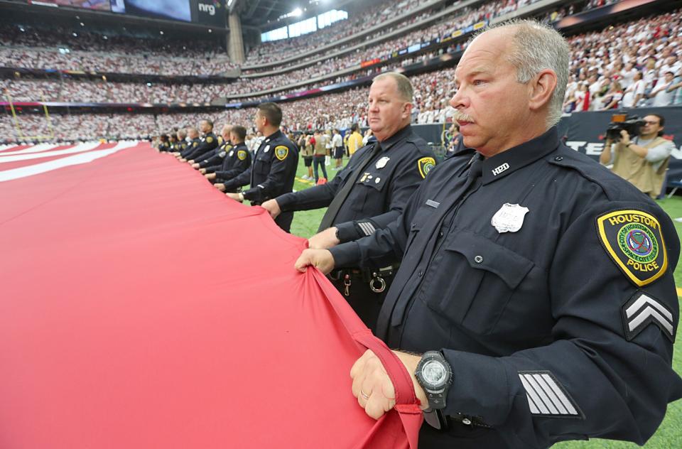 <p>Police officers hold a giant American flag before the Houston Texans play the Chicago Bears at NRG Stadium on September 11, 2016 in Houston, Texas. (Photo by Thomas B. Shea/Getty Images) </p>