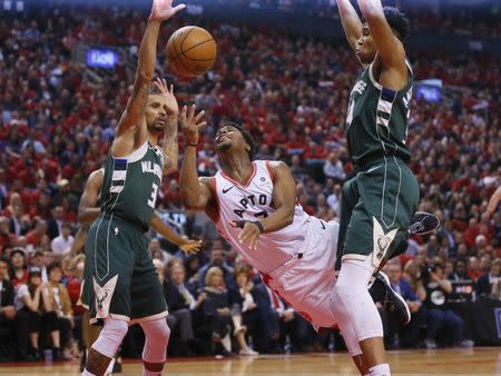 May 21, 2019; Toronto, Ontario, CAN; Toronto Raptors guard Kyle Lowry (7) shoots the ball as Milwaukee Bucks guard George Hill (3) and Bucks forward Giannis Antetokounmpo (34) defend during the first half in game four of the Eastern conference finals of the 2019 NBA Playoffs at Scotiabank Arena. Mandatory Credit: John E. Sokolowski-USA TODAY Sports