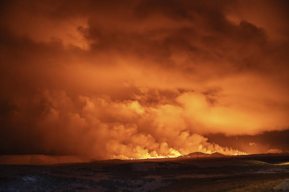 El cielo nocturno se ilumina por una erupción volcánica en Grindavík, en la península de Reykjanes, Islandia, el lunes 18 de diciembre de 2023. (AP Foto/Marco Di Marco)