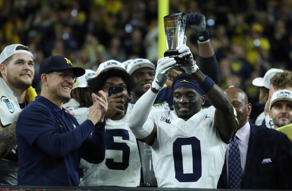 Michigan coach Jim Harbaugh celebrates defensive back Mike Sainristil (0), who was named MVP, after U-M's 26-0 win over Iowa in the Big Ten championship game on Saturday, Dec. 2, 2023, in Indianapolis.