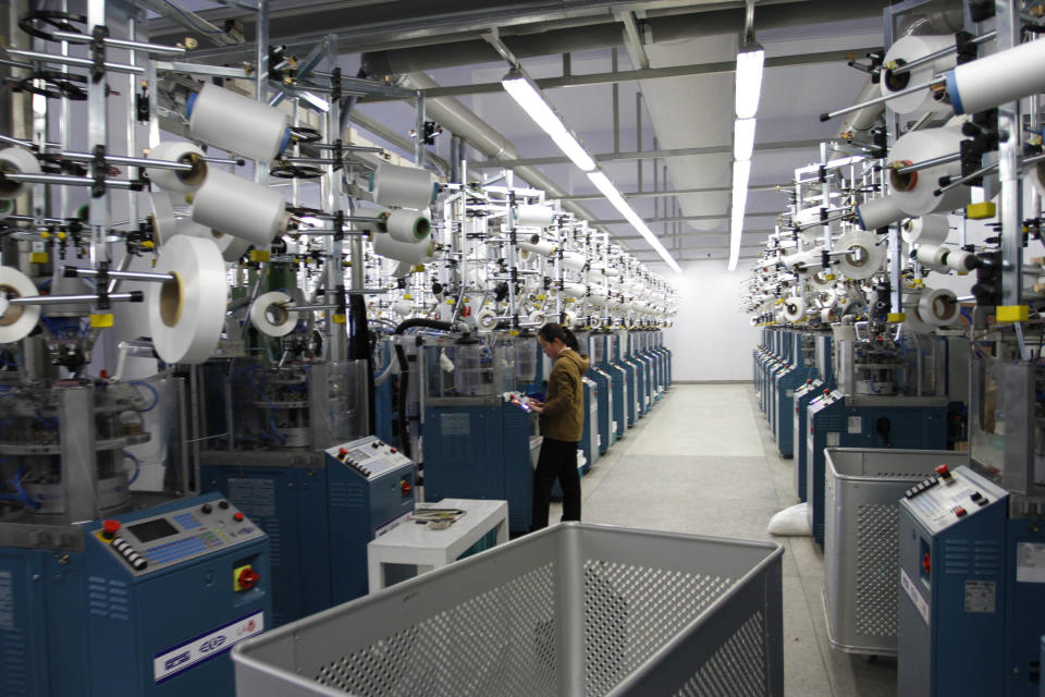 In this Jan. 30, 2012 photo, a woman works with machines inside a factory that produces stockings in Pyongyang, North Korea. A new culture of commerce is springing up, with China as its inspiration and source. The new consumerism is part of a campaign launched three years ago to build up the economy, and so the image of new leader Kim Jong Un. (AP Photo/Kim Kwang Hyon)