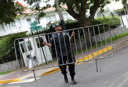 A police officer removes the security fence outside the residence of the Uruguayan ambassador in Peru, after Uruguay rejected asylum to the former Peruvian president Alan Garcia and he left the residence, in Lima, Peru December 3, 2018 REUTERS/Mariana Bazo