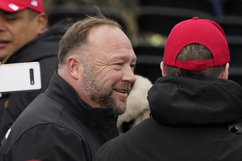 Alex Jones, left, shown at a Jan. 6 rally in Washington in support of President Donald Trump, is seeking bankruptcy protection for some of his companies.