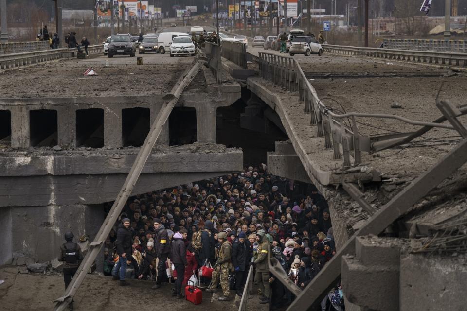 Ukrainians crowd under a destroyed bridge as they try to flee by crossing the Irpin River on the outskirts of Kyiv, Ukraine, March 5, 2022. The image was part of a series of images by Associated Press photographers that was awarded the 2023 Pulitzer Prize for Breaking News Photography. (AP Photo/Emilio Morenatti)