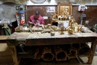 Palestinian worker carves figurines from olive wood to be sold during Christmas season, at a workshop in Bethlehem in the Israeli-occupied West Bank