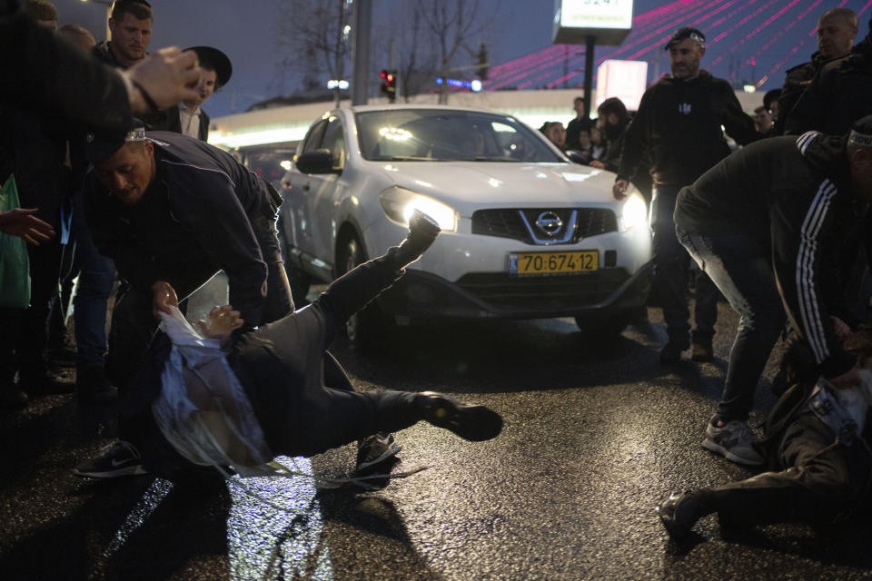 Israeli police officers scuffle with ultra-Orthodox Jewish men during a protest against a potential new draft law which could end their exemptions from military service in Jerusalem, Monday, March 18, 2024. (AP Photo/Leo Correa)