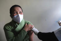 Shimray Wungreichon, 43, looks at the nurse administering her the COVID-19 vaccine at the District Hospital in Ukhrul, in the northeastern Indian state of Manipur, Saturday, Jan. 16, 2021. “I am very positive about it," said Wungreichon, a nurse for 14 years who described getting vaccinated as a “normal routine” for her. (AP Photo/Yirmiyan Arthur)