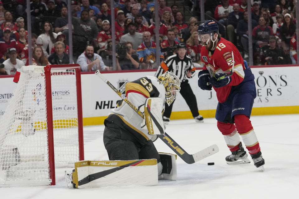 Vegas Golden Knights goaltender Adin Hill (33) goes after a shot on goal by Florida Panthers left wing Matthew Tkachuk (19) during the second period of Game 3 of the NHL hockey Stanley Cup Finals, Thursday, June 8, 2023, in Sunrise, Fla. (AP Photo/Lynne Sladky)