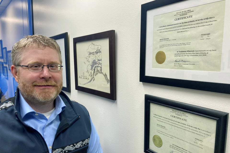 Attorney Scott Kendall stands next to the State of Alaska certificate for the election reforms he helped author in a successful ballot initiative in Anchorage, Alaska, on Jan. 21, 2022. Alaska elections will be held for the first time this year under a voter-backed system that scraps party primaries and sends the top four vote-getters regardless of party to the general election, where ranked choice voting will be used to determine a winner. No other state conducts its elections with that same combination. (AP Photo/Mark Thiessen)