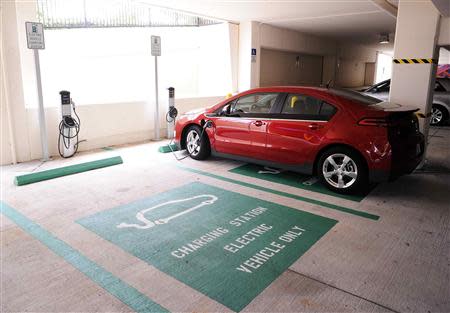 An electric car charges as part of the Drive Electric Orlando program in the parking garage of the Peabody Orlando Hotel in Orlando, Florida September 5, 2013. The initiative is promoting electric car rentals starting with 15 cars available to rent with 26 partner hotels with charging stations while area theme parks have committed to building charging stations. REUTERS/David Manning