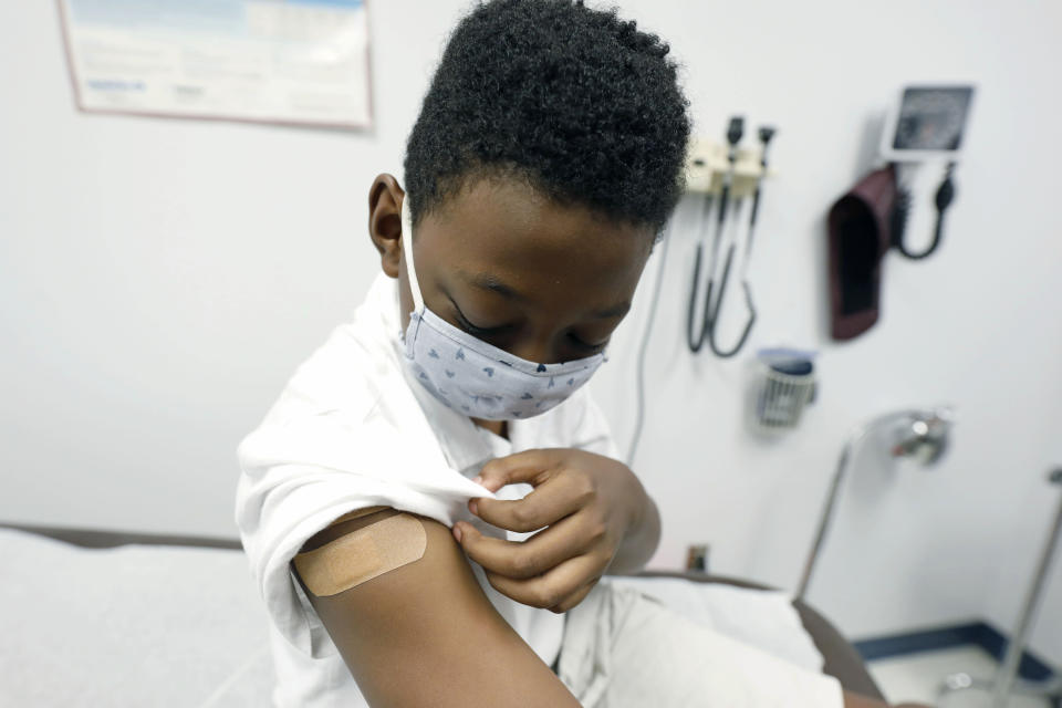 Jeremiah Young, 11, examines his bandage covering during an appointment with Dr. Janice Bacon at the Community Health Care Center on the Tougaloo College campus in Tourgaloo, Miss., Aug. 14, 2020. Bacon works at an all-African American clinic in Hinds County, where the population is overwhelmingly Black and where there have been the most cases of coronavirus reported in the state. (AP Photo/Rogelio V. Solis)