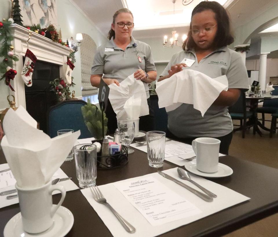 Project SEARCH student Valen Pinckney sets tables in the dining room with skills trainer Amie Smith, Thursday, Dec. 15, 2022, at Grand Villa in Palm Coast. Project SEARCH is a national program for students with disabilities who complete one-year internships to gain work experience and employability skills.