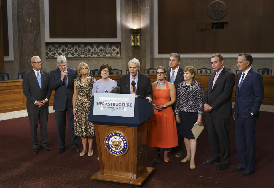 The bipartisan group of Senate negotiators speak to reporters just after a vote to start work on a nearly $1 trillion bipartisan infrastructure package, at the Capitol in Washington, Wednesday, July 28, 2021. From left are Rep. Kevin Cramer, R-N.D., Sen. Bill Cassidy, R-La., Sen. Lisa Murkowski, R-Alaska, Sen. Susan Collins, R-Maine, Sen. Rob Portman, R-Ohio, Sen. Kyrsten Sinema, D-Ariz., Sen. Joe Manchin, D-W.Va., Sen. Jeanne Shaheen, D-N.H., Sen. Mark Warner, D-Va., and Sen. Mitt Romney, R-Utah. (AP Photo/J. Scott Applewhite)