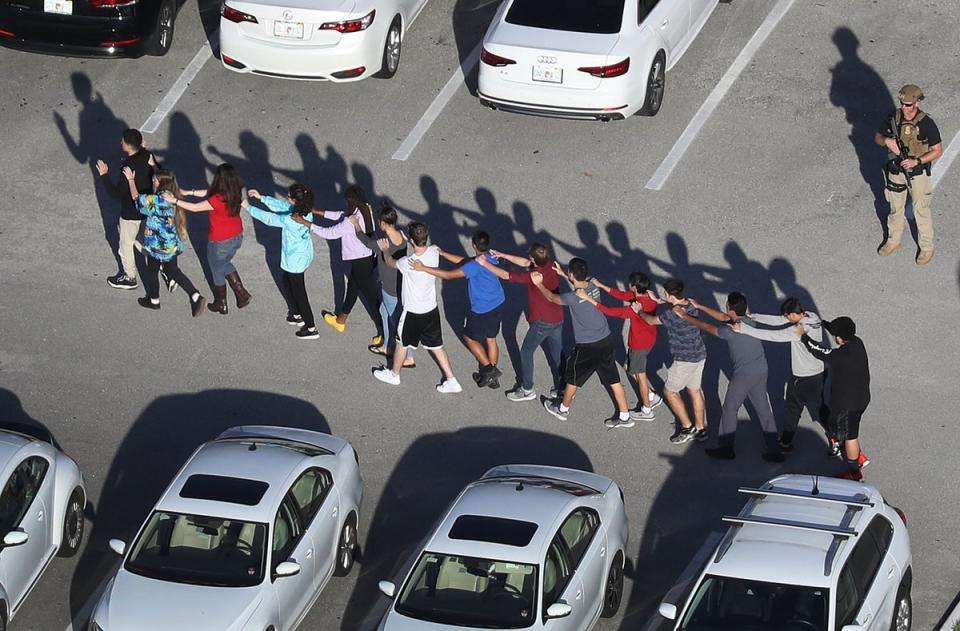 People are brought out of the Marjory Stoneman Douglas High School after the February 14, 2018, Parkland shooting. (Getty Images)