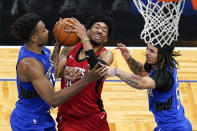 Houston Rockets center Christian Wood, center, attempts a shot against Orlando Magic center Wendell Carter Jr., left, and guard Cole Anthony, right, during the first half of an NBA basketball game, Sunday, April 18, 2021, in Orlando, Fla. (AP Photo/John Raoux)