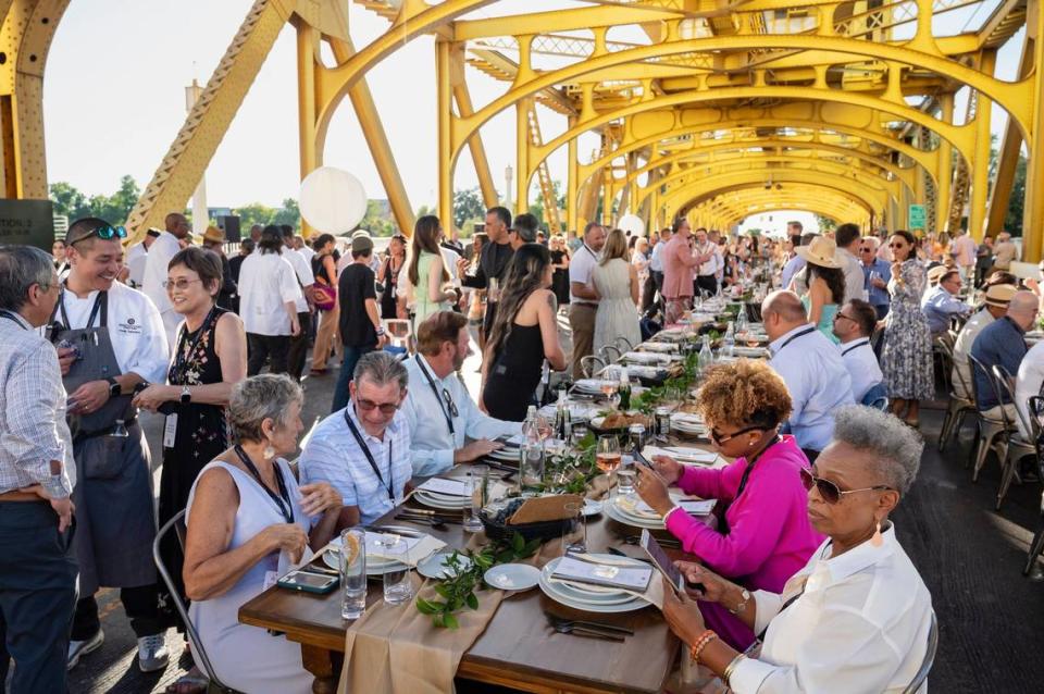 Attendees mingle and start to take their seats for the first course at the Tower Bridge Dinner on the Tower Bridge between Sacramento and West Sacramento on Sunday.