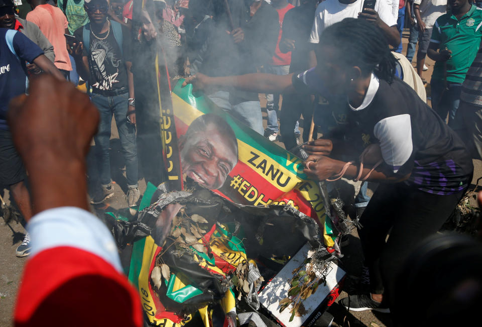 <p>Supporters of the opposition Movement for Democratic Change party (MDC) of Nelson Chamisa burn an election banner with the face of Zimbabwe’s President Emmerson Mnangagwa in Harare, Zimbabwe, August 1, 2018. (Photo: Siphiwe Sibeko/Reuters) </p>