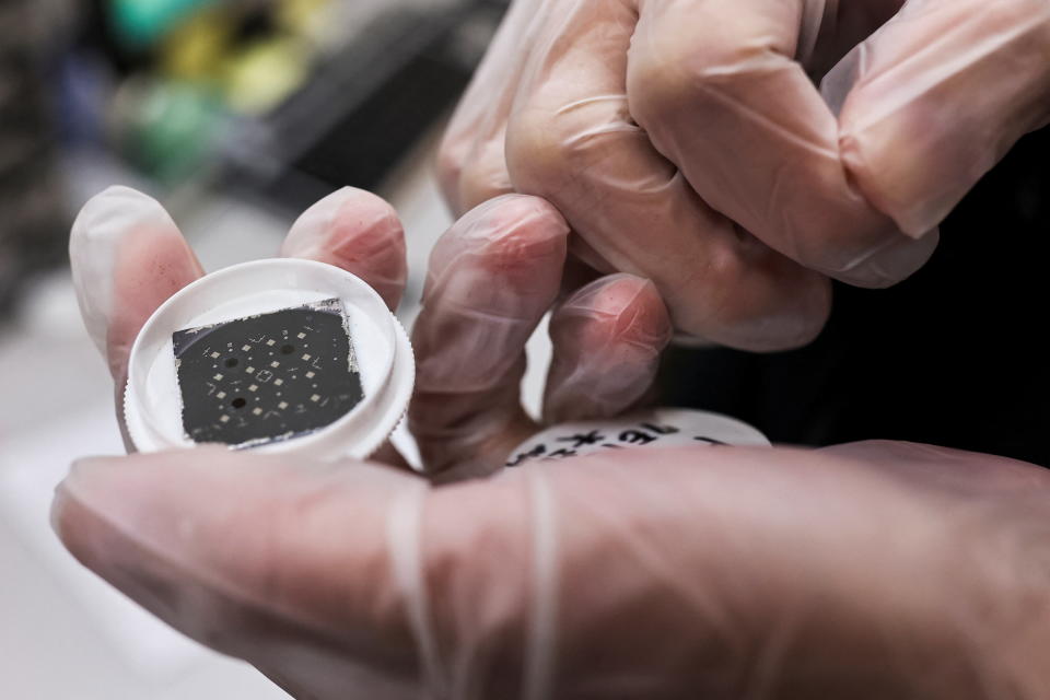 An engineer holds a chip while posing for a photo, he is in the middle of testing reactions from different materials and shapes that can have on the chip at the Taiwan Semiconductor Research Institute (TSRI) in Hsinchu, Taiwan, February 11, 2022. Picture taken February 11, 2022. REUTERS/Ann Wang