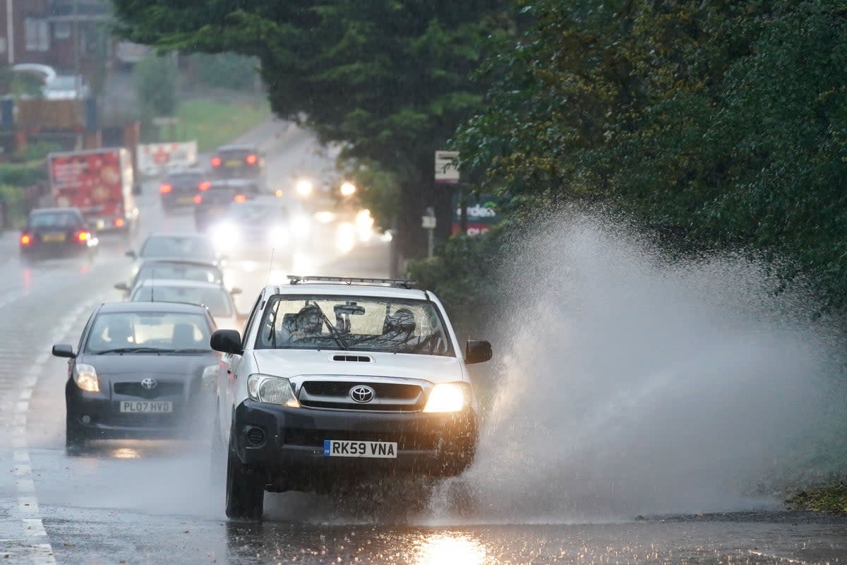 Vehicles travel through standing water during heavy rain in Bromsgrove, West Midlands (Jacob King/PA) (PA Archive)