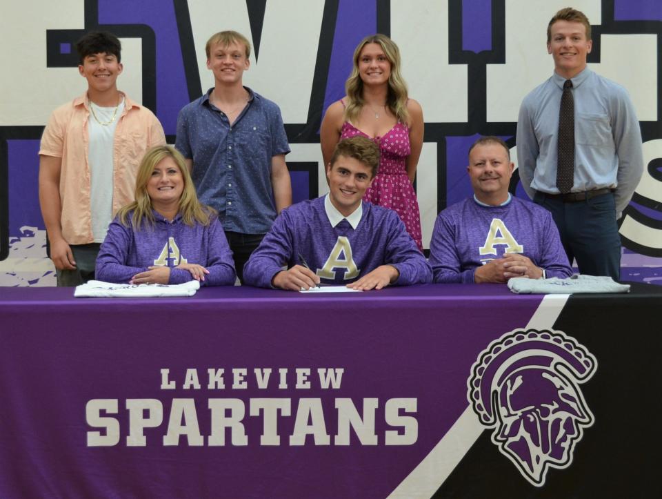 Lakeview's Carson Farkas recently committed to play men's lacrosse at Albion College during a signing ceremony at the high school. He is joined by his family and his coach.