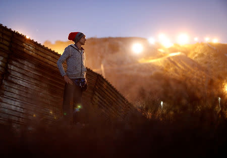 Kevin Jorge Gallardo Antunez, a migrant from Honduras, part of a caravan of thousands traveling from Central America en route to the United States, poses in front of the border wall between the U.S. and Mexico in Tijuana, Mexico, November 23, 2018. REUTERS/Kim Kyung-Hoon