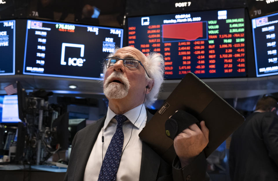 FILE - In this March 16, 2020 file photo, trader Peter Tuchman works on the floor of the New York Stock Exchange. Trading on the NYSE went all-electronic for the first time Monday, March 23 after the exchange temporarily closed its trading floor as a precaution after two employees tested positive last week for the coronavirus. “Things are sort of seamless, as far as speed and execution go,” said Tuchman. He's usually on the NYSE floor trading for Quattro Securities but now working from home. (AP Photo/Craig Ruttle, File)