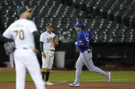 Texas Rangers' Corey Seager, right, runs the bases after hitting a three-run home run against Oakland Athletics pitcher Lucas Erceg, foreground, during the eighth inning of a baseball game Monday, May 6, 2024, in Oakland, Calif. (AP Photo/Godofredo A. Vásquez)
