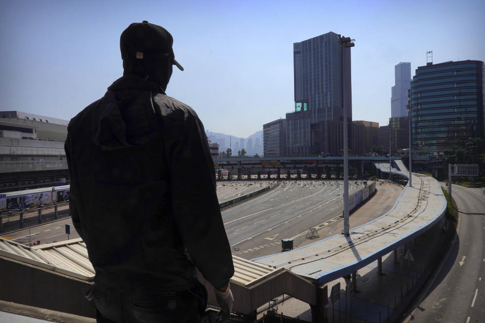 A protester stands near the entrance to the closed Cross-Harbour Tunnel in Hong Kong, Friday, Nov. 15, 2019. Protesters who have barricaded themselves in a Hong Kong university partially cleared a road they were blocking and demanded that the government commit to holding local elections on Nov. 24. (AP Photo/Vincent Yu)