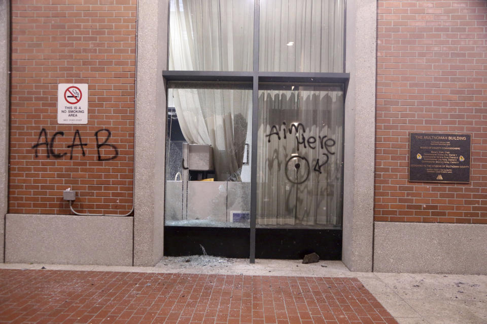 A small fire was set inside of the Multnomah Building during a protest on Tuesday, Aug. 18, 2020, in Portland, Ore. Protesters in Portland broke out the windows of a county government building, sprayed lighter fluid inside and set a fire in a demonstration that started Tuesday night and ended Wednesday morning with clashes with police, officials said. (Beth Nakamura/The Oregonian via AP)
