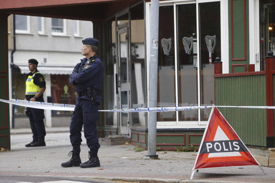 Police stand outside a pub where two people were killed and two wounded following a shooting, in Sandviken, some 162 kilometers (100 miles) northwest of Stockholm, Friday, Sept. 22, 2023. In a statement, police said that a man in his 20s and another in his 70s died Friday of injuries sustained in the shooting late Thursday at the pub in Sandviken. (Henrik Hansson/TT News Agency via AP)