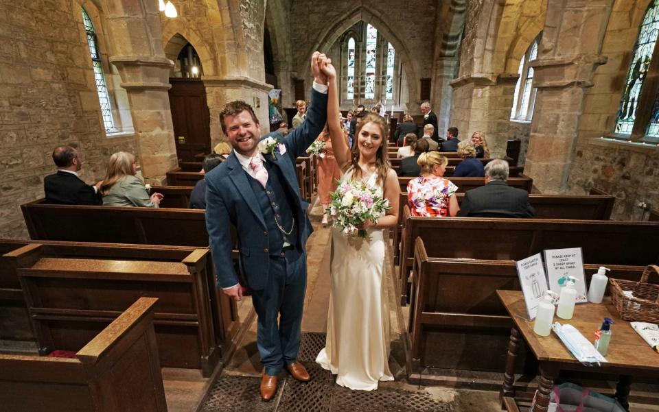 Lucy Johnston, 25, and James Bone, 28, celebrate their wedding in Northumberland on July 4, as ceremonies were again permitted, but with a maximum of 30 guests - Owen Humphreys/PA