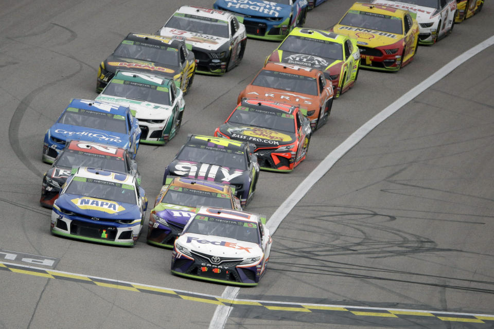 Denny Hamlin, front right, leads the pack out of the final caution before winning a NASCAR Cup Series auto race at Kansas Speedway in Kansas City, Kan. Sunday, Oct. 20, 2019. (AP Photo/Charlie Riedel)