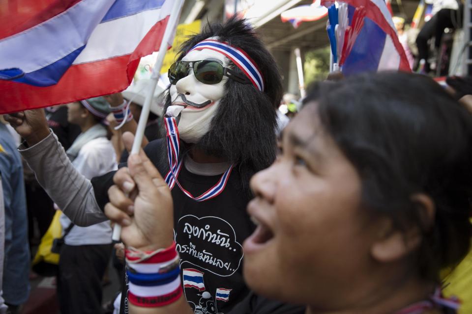 Anti-government protestors chant outside the Royal Thai Police headquarters in the Pathumwan district, Tuesday, Jan. 14, 2014, in Bangkok. Anti-government protesters who blocked off intersections across Thailand's capital began marching toward several government ministries Tuesday on the second day of a renewed push to derail elections next month and unseat the prime minister. (AP Photo/John Minchillo)