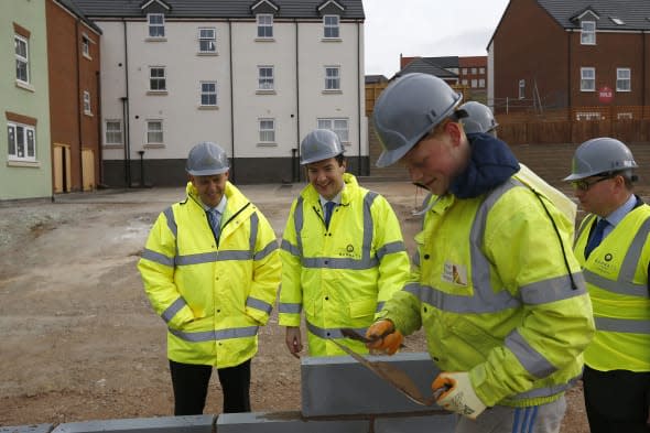 Chancellor of the Exchequer George Osborne watches a trainee lay a block  during a visit to a Barratt Homes building site in Nuneaton, the day after he said in his annual budget that the government would extend the equity loan portion of the Help to Buy scheme for four years longer than planned to 2020, a move he said would deliver 120,000 new homes.