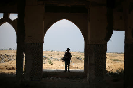 Palestinian songbird catcher Hamza Abu Shalhoub, 16, looks for birds at the site of Gaza destroyed airport, in Rafah in the southern Gaza Strip November 8, 2018. Picture taken November 8, 2018. REUTERS/Ibraheem Abu Mustafa