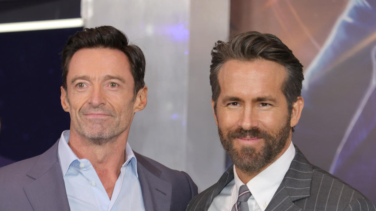  Ryan Reynolds and Hugh Jackman smiling on the red carpet of The Adam Project. 