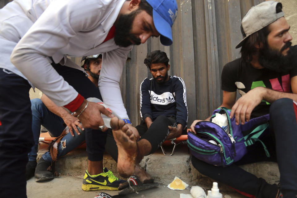 An injured person receives first aid during clashes between Iraqi security forces and anti-government demonstrators, in downtown Baghdad, Iraq, Wednesday, Nov. 13, 2019. (AP Photo/Hadi Mizban)