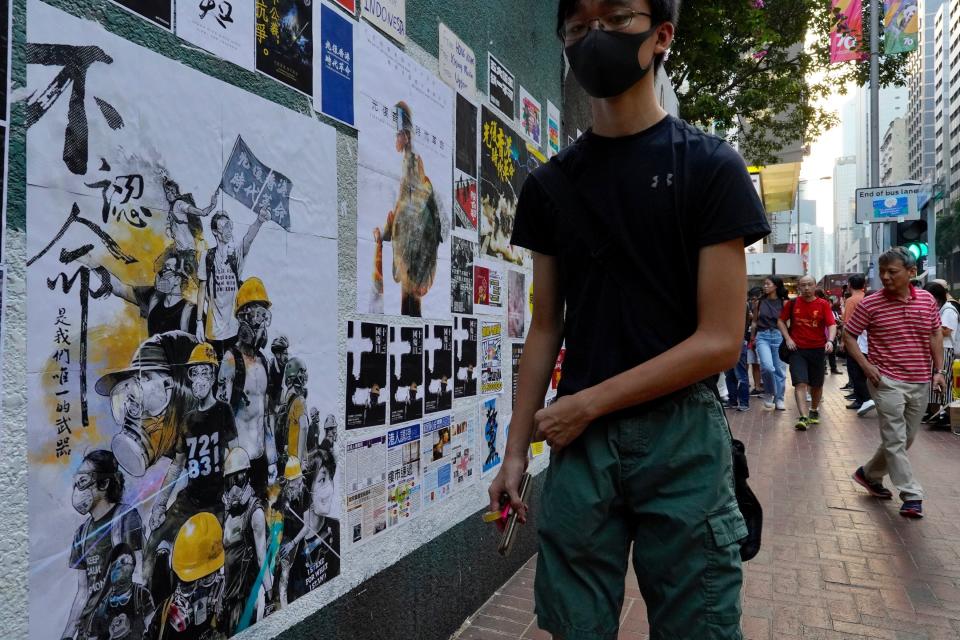 Pedestrian walk past a newly created Lennon Wall in Hong Kong, Saturday, Sept. 28, 2019. Hong Kong activists first created their own Lennon Wall during the 2014 protests, covering a wall with a vibrant Post-it notes calling for democratic reform. Five years later, protestors have gathered to create impromptu Lennon Walls across Hong Kong island. (AP Photo/Vincent Yu)