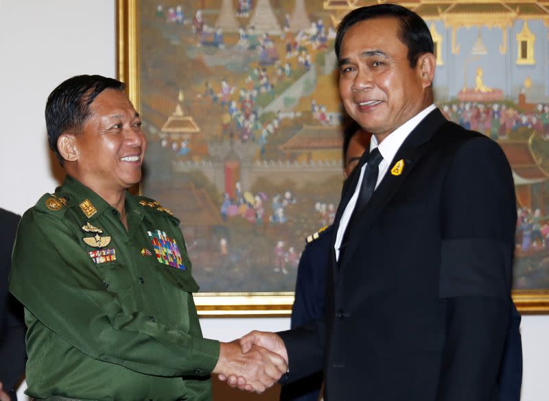 Myanmar's military Chief Senior-General Min Aung Hlaing (L) shakes hands with Thailand's Prime Minister Prayuth Chan-ocha at Government House in Bangkok