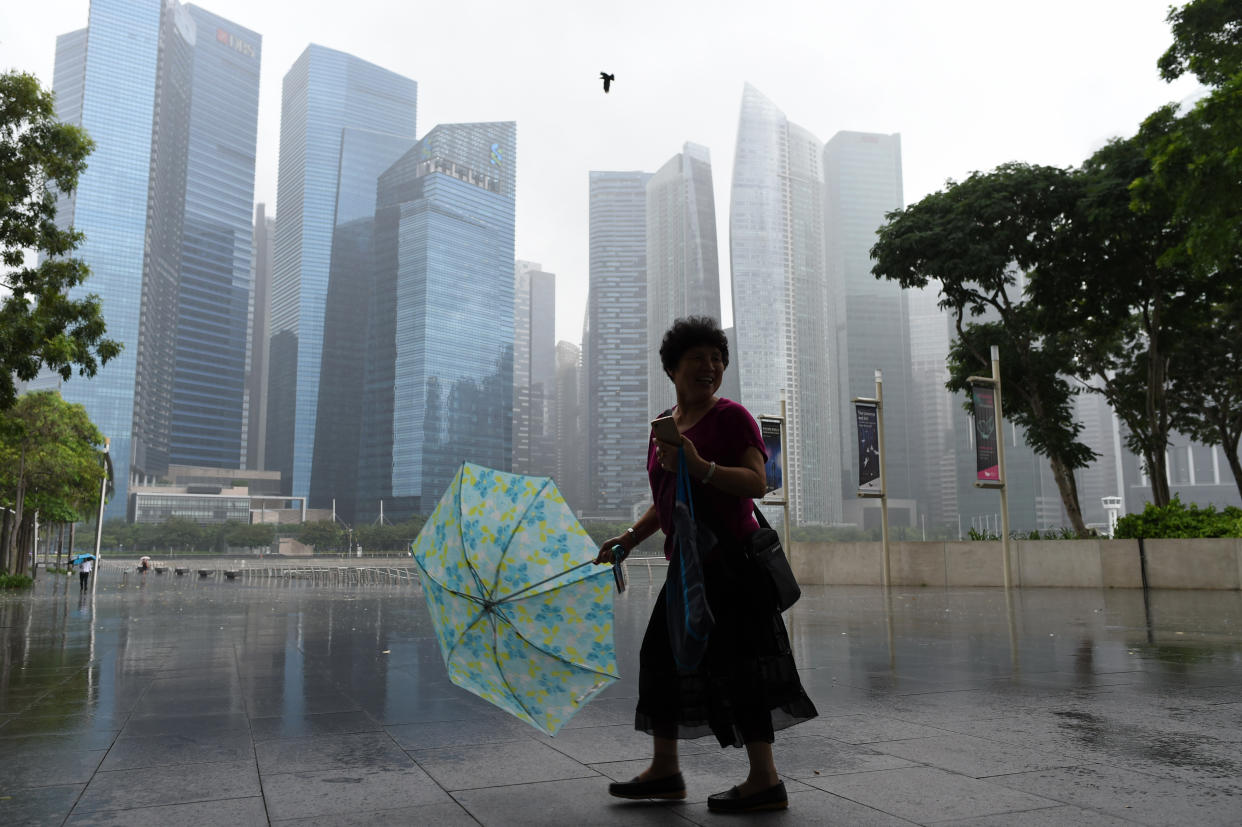 A woman with an umbrella walks away from the rain in Singapore on March 30, 2017. (ROSLAN RAHMAN/AFP/Getty Images)