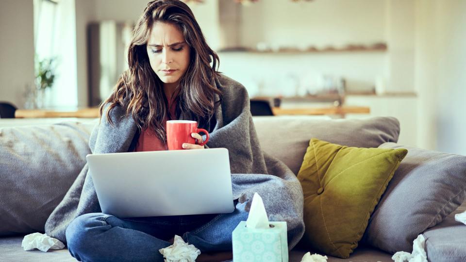 Sick looking woman at laptop