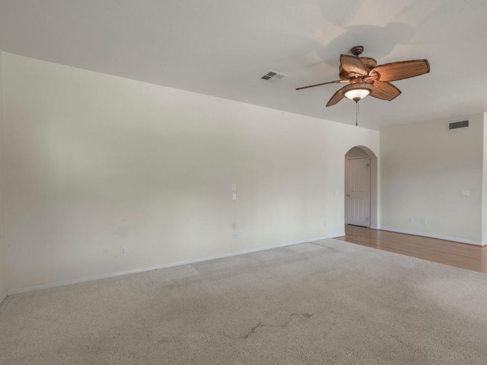 An empty living room with grey walls.