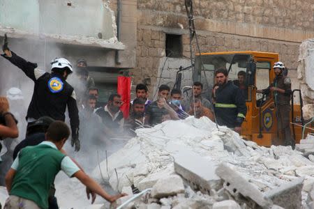 Civil defence members and civilians search for survivors under the rubble of a damaged site hit by airstrikes in Idlib, Syria September 29, 2016. REUTERS/Ammar Abdullah