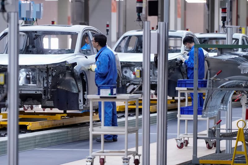 FILE PHOTO: Employees work on assembly line during a construction completion event of SAIC Volkswagen MEB electric vehicle plant in Shanghai