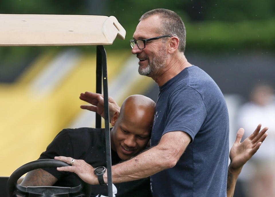 FILE - In this May 31, 2018, file photo, injured Pittsburgh Steelers linebacker Ryan Shazier, left, and former Steelers lineman and current broadcaster, Tunch Ilkin, embrace at an NFL football practice in Pittsburgh. Ilkin, a Turkis-born two-time Pro Bowl offensive lineman with the Pittsburgh Steelers in the 1980s who went on to become a beloved member of the organization's broadcast team, died on Saturday morning, Sept. 4, 2021, the team said. He was 63. Ilkin, who revealed last fall he was fighting amyotrophic lateral sclerosis (also known as Lou Gehrig's Disease), had been hospitalized recently with pneumonia. (AP Photo/Keith Srakocic, File)