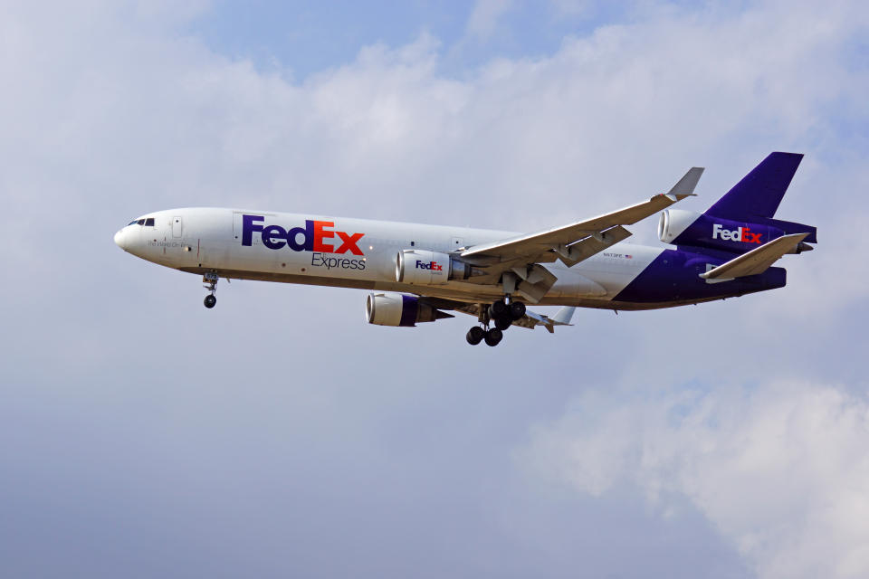 Ontario, California,USA- April 28,2016. Airplane FedEx MD-11 freight cargo jumbo jet landing at Ontario International Airport, outside Los Angeles, California. Ontario Airport serves as a hub for FedEx.