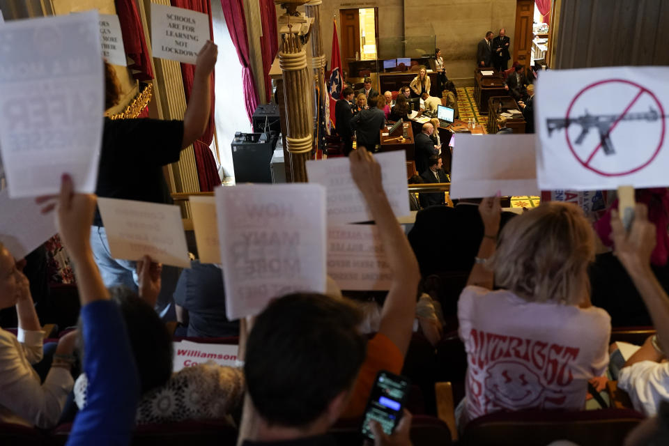 People hold signs in the House gallery above the chamber floor advocating for gun law reform during a special session of the state legislature on public safety Monday, Aug. 28, 2023, in Nashville, Tenn. (AP Photo/George Walker IV)