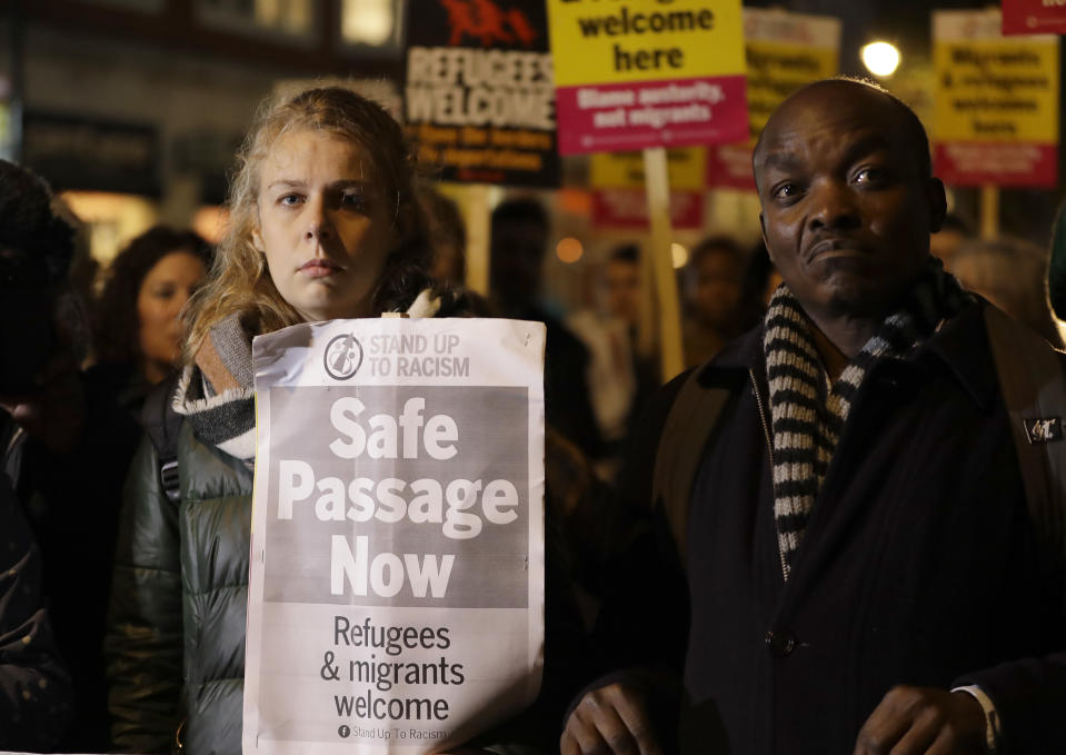 Demonstrators hold banners during a vigil for the 39 lorry victims, outside the Home Office in London, Thursday, Oct. 24, 2019. Authorities found 39 people dead in a truck in an industrial park in England on Wednesday and arrested the driver on suspicion of murder in one of Britain's worst human-smuggling tragedies. (AP Photo/Kirsty Wigglesworth)