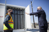 Gov. Jay Inslee, right, speaks to principal engineer Scott Gibson about the Microgrid batteries Tuesday, April 20, 2021, in Arlington, Wash. (Olivia Vanni/The Herald via AP)